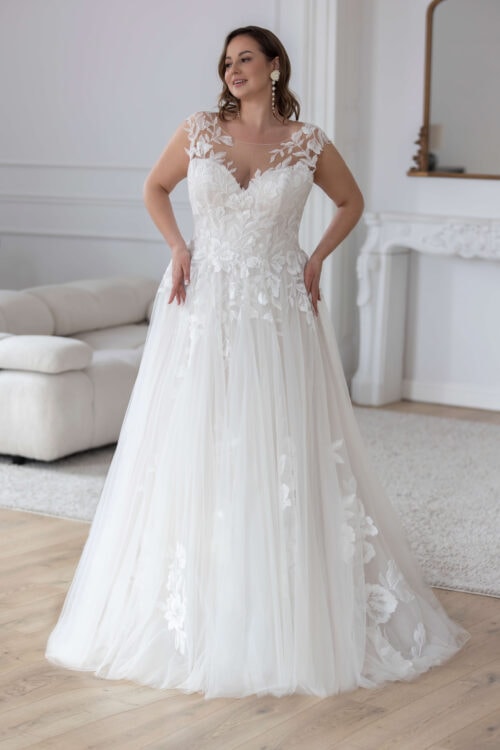 Jarice Bridal. Model Glasgow. Smuk og romantisk A-line budekjole i tyl. Kjolen har blonder på overkroppen som fader ned på skørtet. Den har en hjerteudskåret corsage som er dæket med mesh der giver kjolen brede stropper, bådudskæring og en lukket dekoativ ryg med blonder.