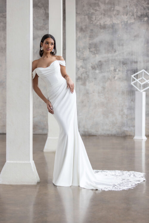 Jarice Bridal. Model Fantastic. Virkelig smuk og skulpturel slank brudekjole. Draperingerne hen over harn og hofter fremhæver den kvindelige figur. Kjolen har aftageige off-shoulder stropper og et smukt slæb der afsluttes med blonder.
