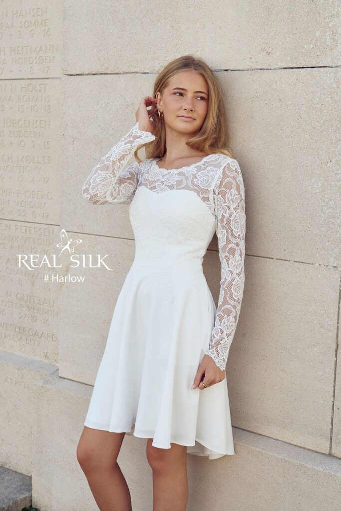 Real Silk Harlow konfirmationskjole med lange blondeærmer, tætsiddende overdel og skørt med længere bagstykke