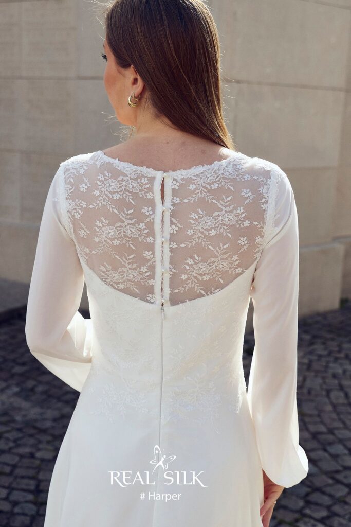 Rygdetalje på Real Silk Harper konfirmationskjole med transparent tyl, blomsterbroderi og tre knapper