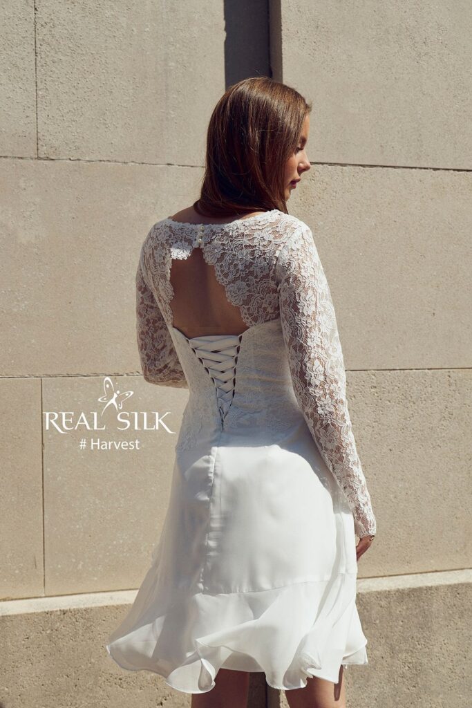 Real Silk Harvest konfirmationskjole bagfra med blondeærmer, åben ryg, knapper og snørelukning