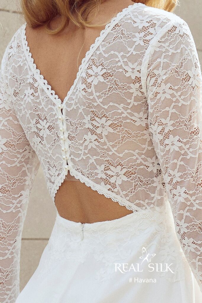 Rygdetalje på Real Silk Havana konfirmationskjole med V-formet blomsterblonde, knapper og åben talje
