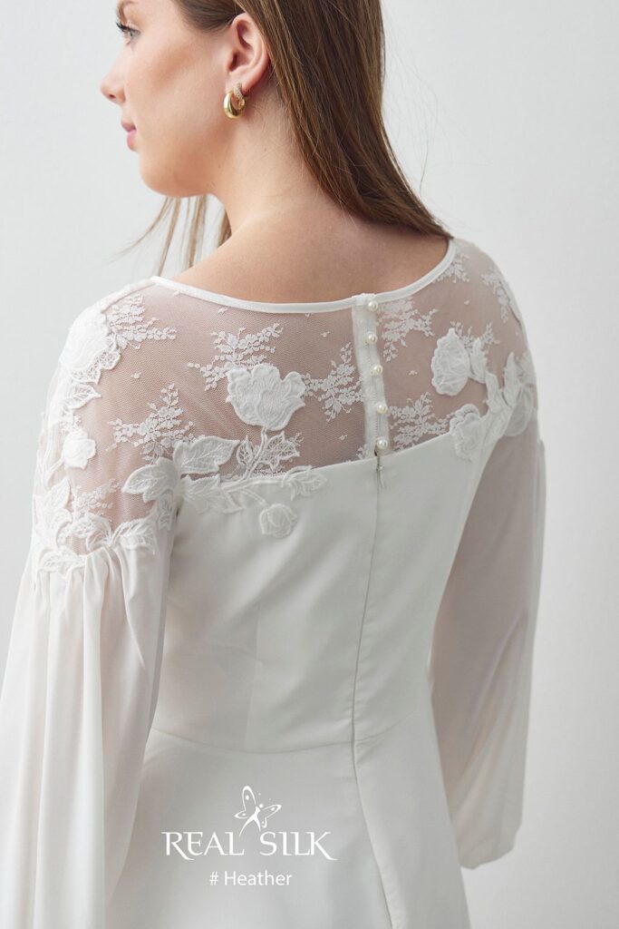 Rygdetalje på Real Silk Heather konfirmationskjole med transparent tyl, blomsterapplikationer, perleknapper og lynlås