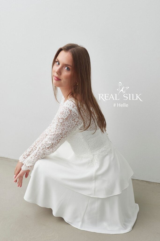 Real Silk Helle konfirmationskjole fra siden med blondeoverdel, transparent ærme og peplum over lagdelt skørt