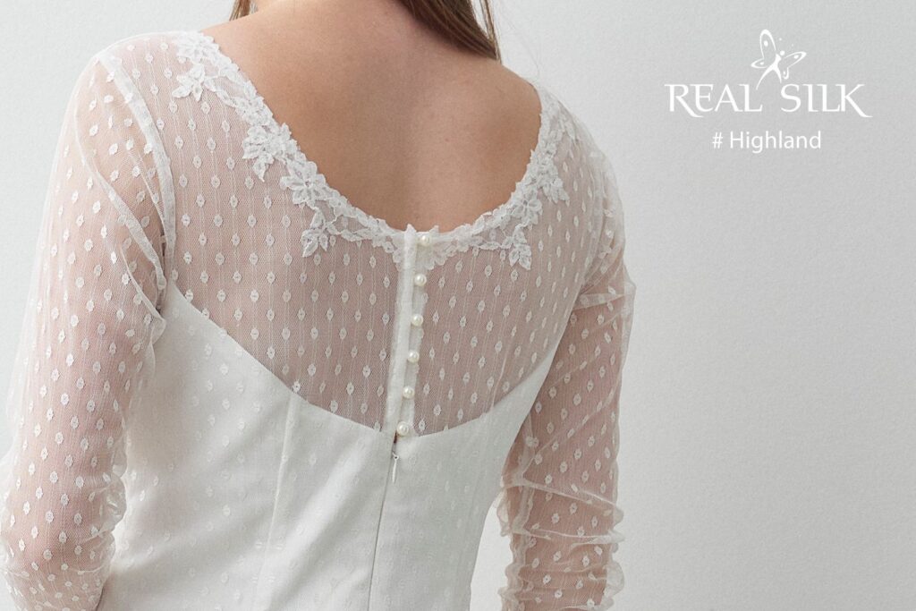 Rygdetalje på Real Silk Highland konfirmationskjole med prikket tyl, blondekant, perleknapper og lynlås
