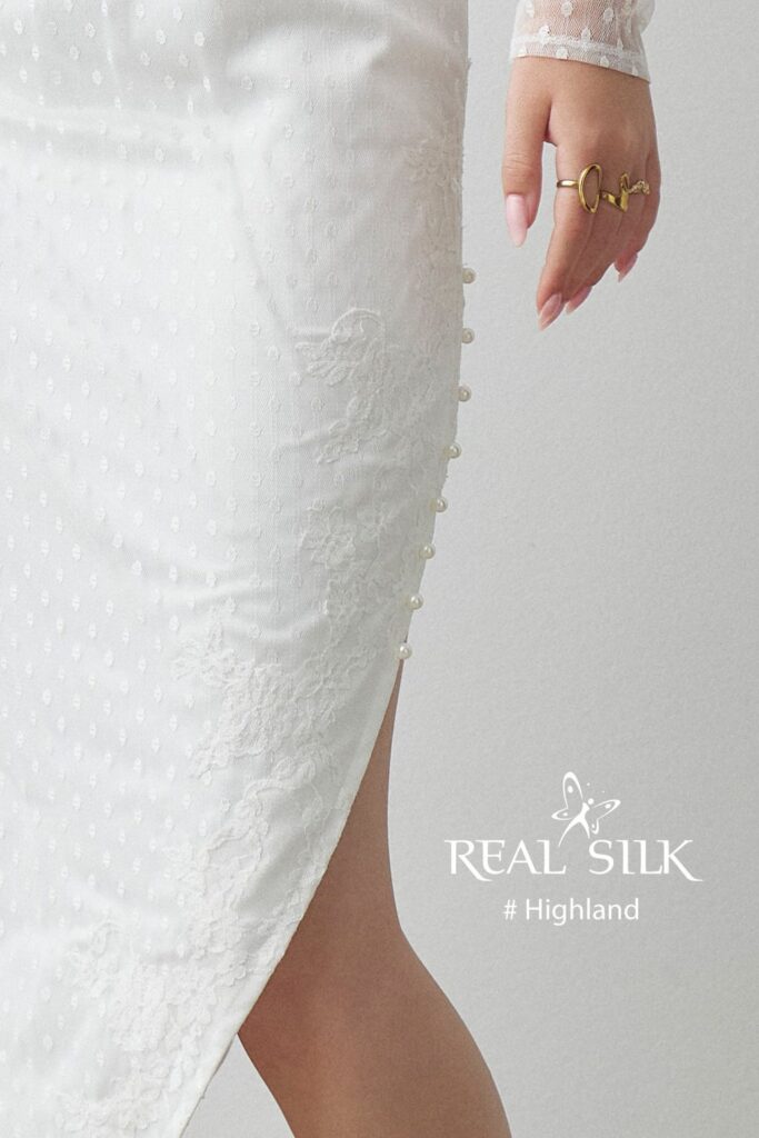 Sideslids på Real Silk Highland konfirmationskjole med perlelignende knapper, prikket stof og blondekant